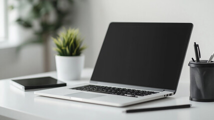 Modern workspace minimal design, sleek silver laptop placed next to green potted plant, bright natural lighting