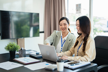 Female senior and junior managers sitting at desk working together in a business team
