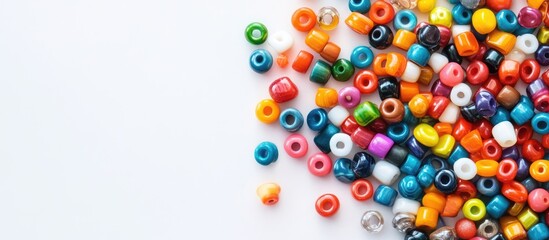 Colorful assortment of vibrant handmade beads scattered on the left side of a clean white surface showcasing the art of DIY jewelry making