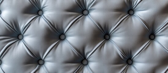 Fototapeta premium Textured blue leather upholstery with tufted buttons in a symmetrical pattern showcasing glossy surface and shadows for depth.