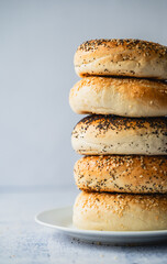 Close up of stack of assorted bagels on plate.