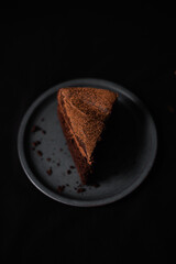 Slice of rich chocolate cake with cocoa powder