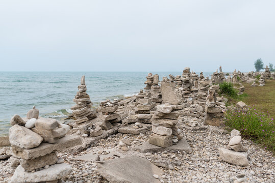 Man-made stacked rock cairns along Lake Huron shoreline