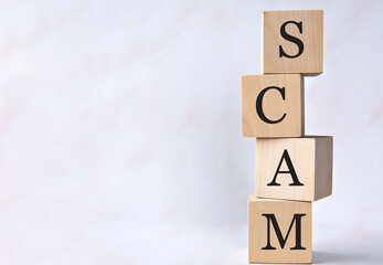 SCAM - acronym on wooden cubes on a white background