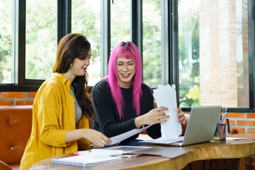 LGBTQ+ transgender man Beautiful Authentic Specialist with Pink Hair and Non-binary trans working together Working Design in creative workplace team work colleagues Gender equality