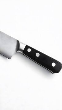 2. A close-up of a modern chef is knife lying flat on a clean white surface, focusing on the blade and handle details