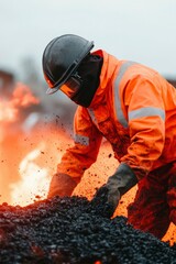 Fototapeta premium Worker in protective gear handles molten asphalt
