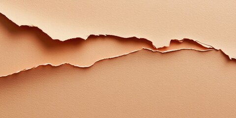 Torn peach paper background with wavy edges creating a textured contrast on a smooth beige surface emphasizing layers and depth.