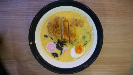 Cheese ramen noodles with several toppings such as boiled eggs and appetizing chicken