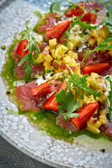 A vibrant and refreshing salad featuring thinly sliced tuna, fresh strawberries, and a zesty dressing