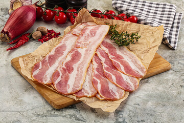 Sliced pork bacon over board