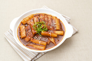 Tteokbokki or Topokki, stir fried rice cake stick, popular Korean street food with spicy gochujang sauce and sesame seed. 
