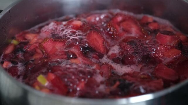 Various berries being boiled in a pot.