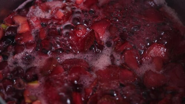 Various berries being boiled in a pot. Top view