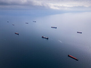 An aerial perspective of cargo ships floating on the open sea, representing global trade and...