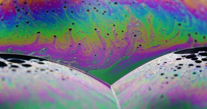 Science experiment showing the colorful dance of liquids in a soap bubble