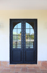 Metal glass door of the restaurant against white cement wall. Elements of architecture of buildings.