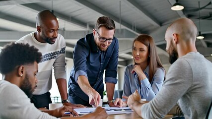 Business team collaborating on project in modern office. Diverse business team engaged in a discussion, analyzing documents and planning a project in a modern workspace.