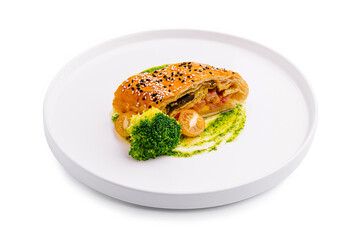 Culinary art featuring a gourmet pastry with vegetables presented on a minimalist plate
