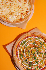 Delicious pizzas displayed on a vibrant orange background, showcasing cheese and unique toppings with fresh ingredients