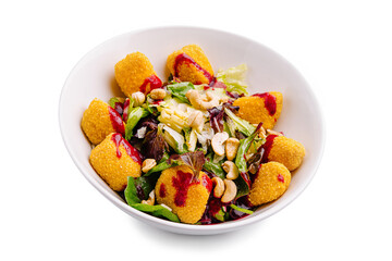 Colorful salad with crispy bites, fresh greens, and zesty dressing served in a bowl on a white background