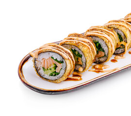Delicious sushi rolls topped with creamy sauce and served on a white plate