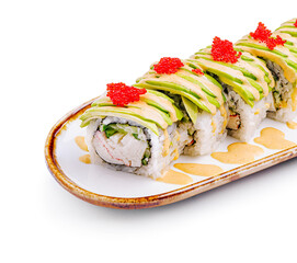 Delicious sushi roll topped with avocado and fish roe served on a decorative plate