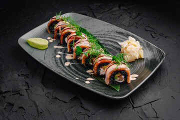 Exquisite sushi rolls beautifully arranged on a modern black plate with garnishes