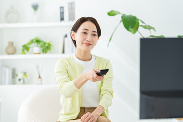リビングでテレビを見るミドルの女性