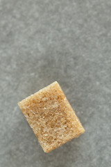 A brown sugar cube close-up on a gray surface
