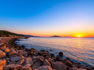 Obraz premium Vibrant orange and pink sunset casting a warm glow over the rocky shoreline of Cala d'Hort Beach in Ibiza Island, pink, vibrant, sunset