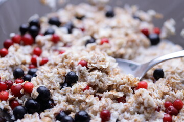 A warm bowl of oatmeal topped with mixed berries and blueberries, perfect for breakfast or brunch.