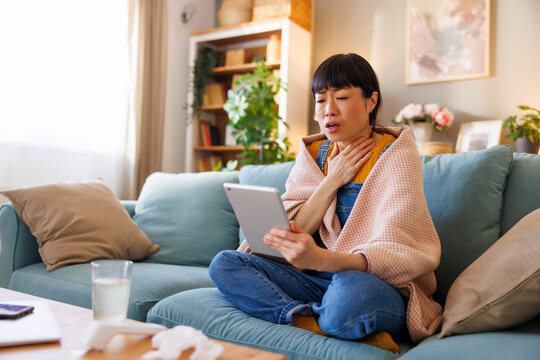 Sick woman having online doctor's appointment while having fever and flu