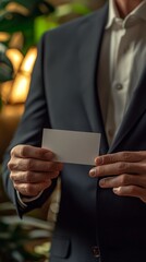 Impiegato d'azienda tiene un biglietto da visita privo di informazioni, bianco e vuoto, pronto per presentarsi.