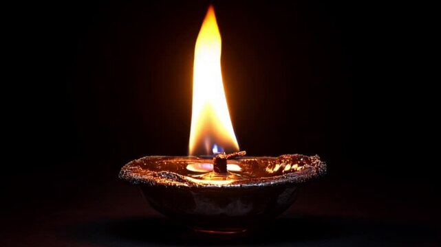Single oil lamp flame glowing dark background, hope, peace, spirituality