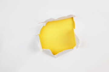 Torn ripped paper hole isolated on yellow background