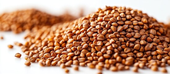 Obraz premium Buckwheat seeds in a mound on a white background highlighting their natural texture and nutrition for culinary and health applications