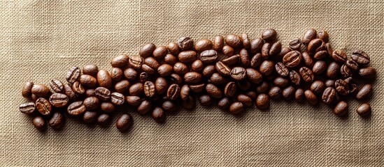 Coffee beans arranged in a downward trending graph on a textured creamy canvas background viewed from above.