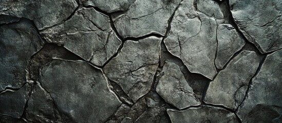 Fototapeta premium Textured cracked stone surface background with irregular shapes and dark tones suitable for various design applications Copy Space