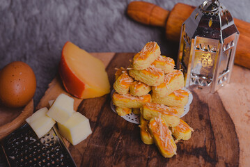 Kastengel or Dutch version of kaasstengels is Indonesian cheese stick or cheese cookies. its popular cookies that Indonesian household will have during a festive celebration. selected focus, wooden