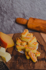 Kastengel or Dutch version of kaasstengels is Indonesian cheese stick or cheese cookies. its popular cookies that Indonesian household will have during a festive celebration. selected focus, wooden