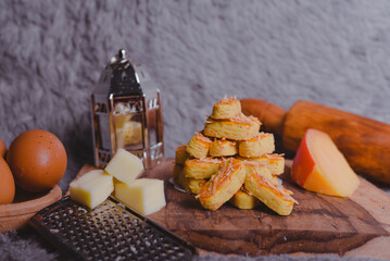Kastengel or Dutch version of kaasstengels is Indonesian cheese stick or cheese cookies. its popular cookies that Indonesian household will have during a festive celebration. selected focus, wooden
