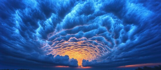 Dramatic cloud formations resembling tiger stripes against a vibrant blue sky at sunset creating a stunning background scene.