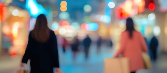 Fototapeta premium Blurred Evening Shopping Scene with Shoppers Carrying Bags and Empty Copyspace for Text in a Colorful Urban Environment