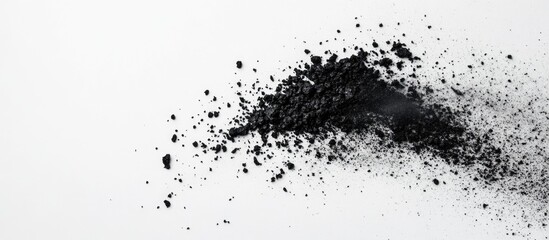 Obraz premium Fine black ash scattered on a clean white background creating a contrast in textures and colors for visual impact.