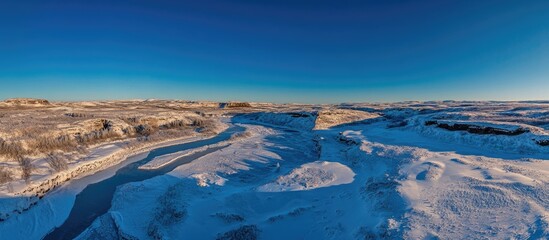 Aerial perspective of a stunning frozen landscape in rural Iceland showcasing ice formations and clear blue skies.