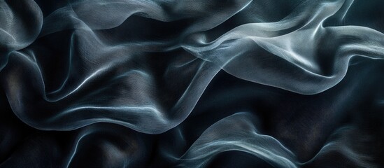 Obraz premium Soft flowing waves of black fabric on an abstract background creating a serene and elegant texture ideal for design projects.