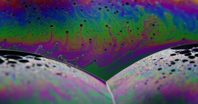 Vibrant rainbow colors and complex fluid dynamics on the surface of soap bubbles