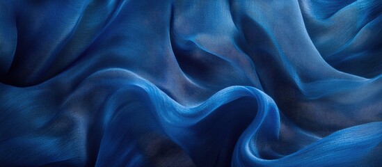 Obraz premium Elegant blue silk fabric texture with wavy folds creating a luxurious and abstract background for design and wallpaper applications