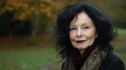 Fototapeta premium Elegant Elderly Woman with Beautiful Curly Hair in Autumn Park Scene